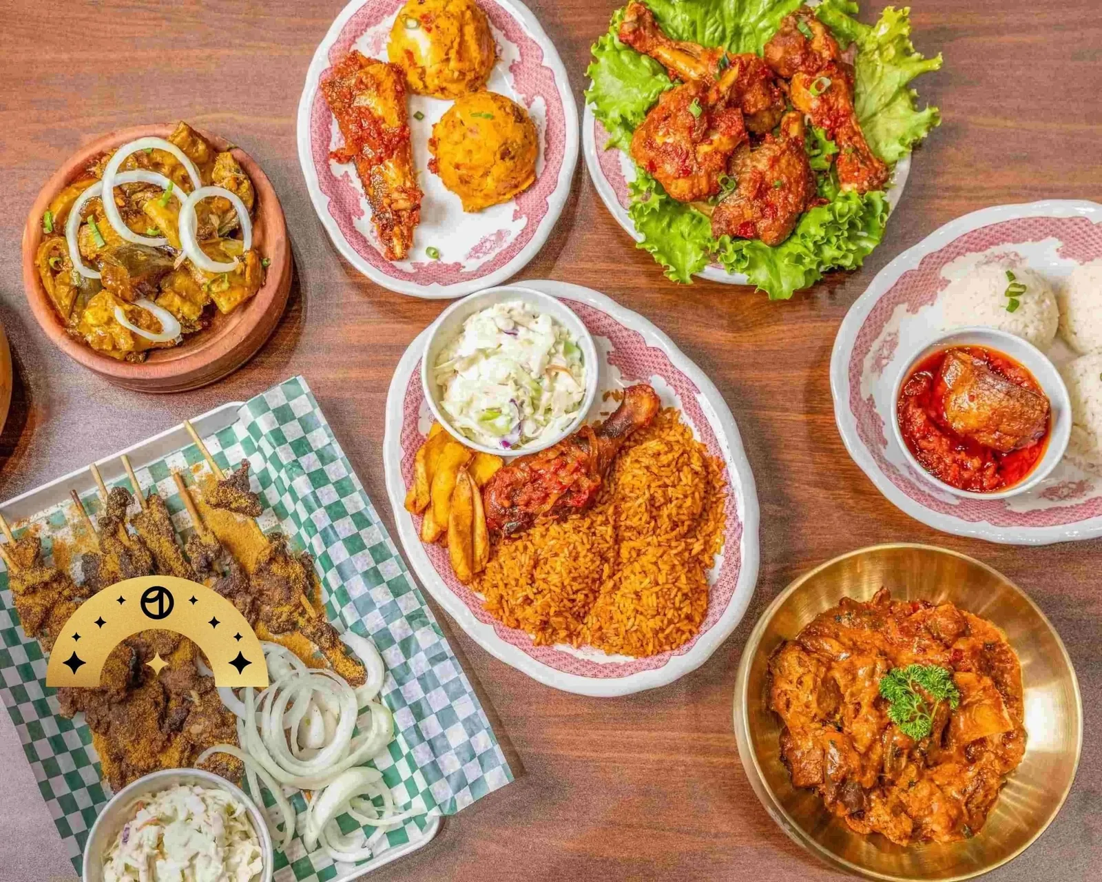 Table spread of West African dishes including Jollof rice, suya skewers and grilled chicken at Royal Premium Restaurant, Saskatoon